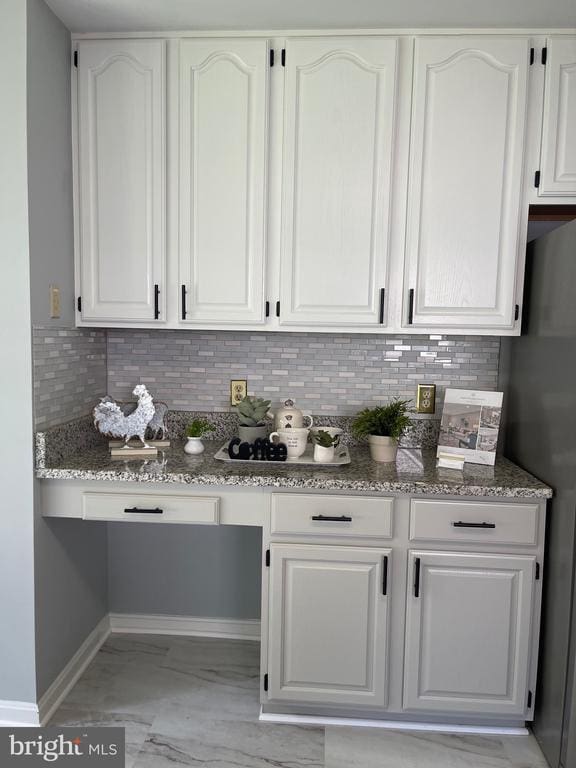 4209 Oakhill Rd, Fredericksburg, VA 22408 - kitchen featuring light stone countertops, white cabinets, light marble finish floors, and decorative backsplash