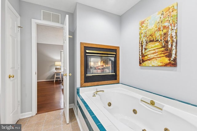4209 Oakhill Rd, Fredericksburg, VA 22408 - full bathroom with a jetted tub, a multi sided fireplace, and tile patterned flooring