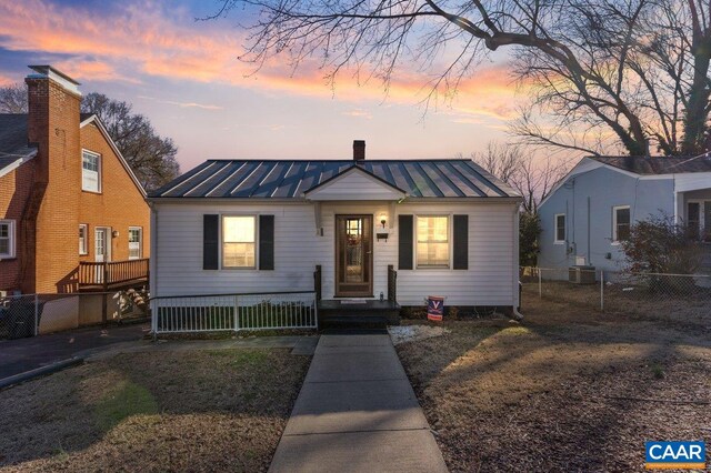 bungalow-style home with metal roof, a standing seam roof, and fence private yard