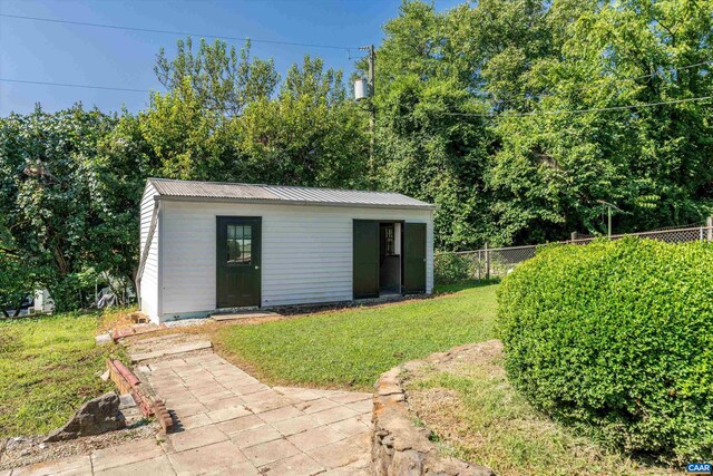 view of outbuilding with fence and an outbuilding