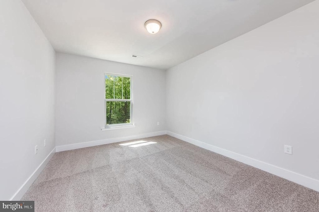 spare room with carpet and baseboards
