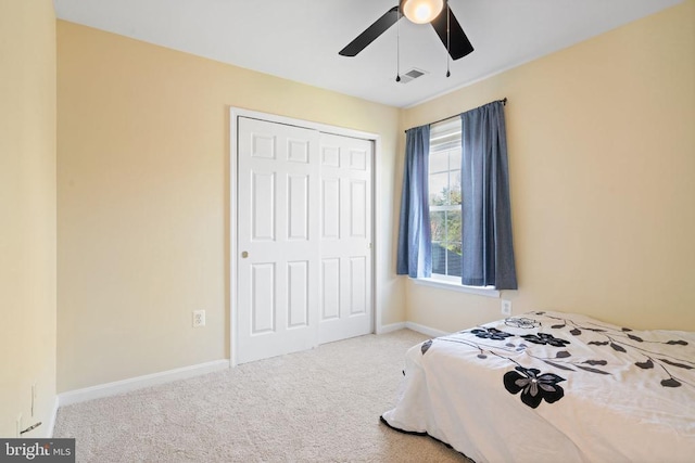 carpeted bedroom with a closet, baseboards, and ceiling fan