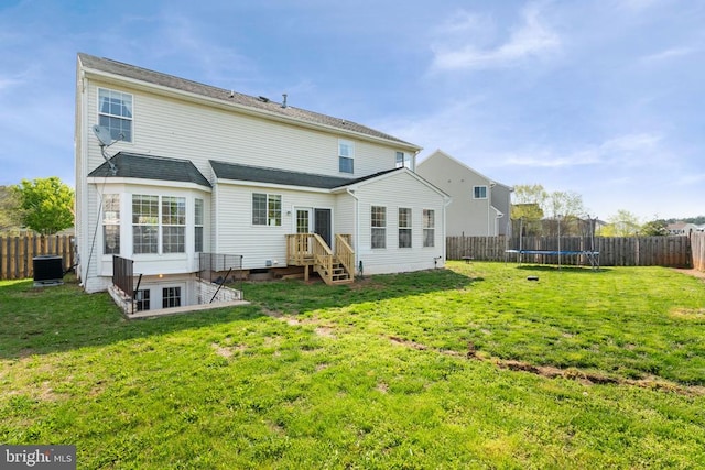 rear view of property with cooling unit and a trampoline