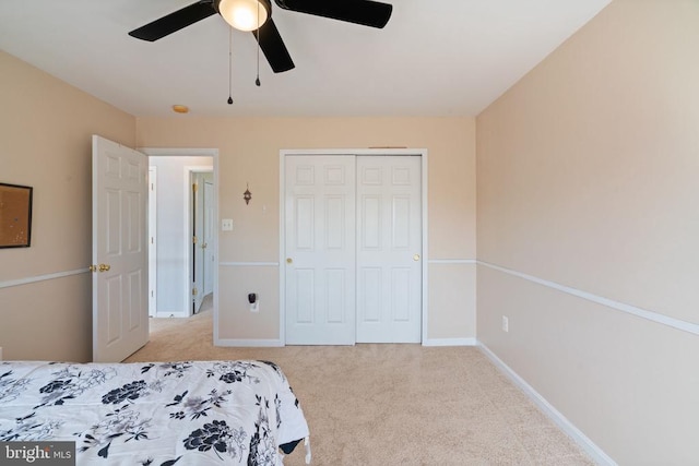 carpeted bedroom with a closet, ceiling fan, and baseboards