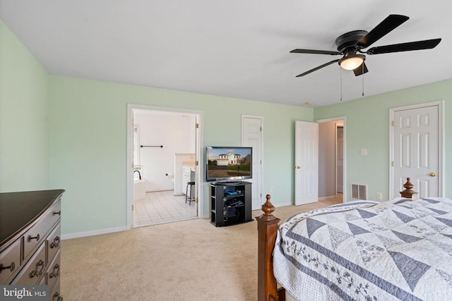 bedroom with light colored carpet, baseboards, and ensuite bathroom