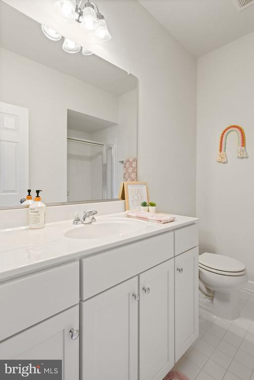 10430 Aspen Highlands Dr, Spotsylvania, VA 22553 - bathroom with tile patterned floors, toilet, vanity, and a shower with door