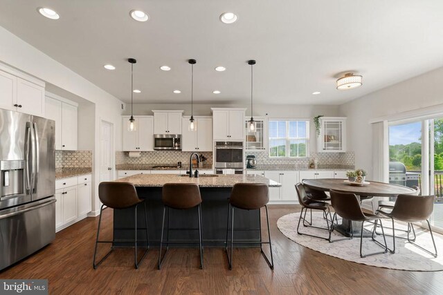 10430 Aspen Highlands Dr, Spotsylvania, VA 22553 - kitchen with appliances with stainless steel finishes, a kitchen island with sink, dark wood-style floors, tasteful backsplash, and recessed lighting