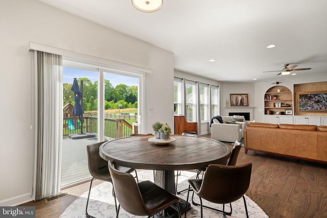 10430 Aspen Highlands Dr, Spotsylvania, VA 22553 - dining space with wood finished floors, a fireplace, a ceiling fan, built in features, and baseboards