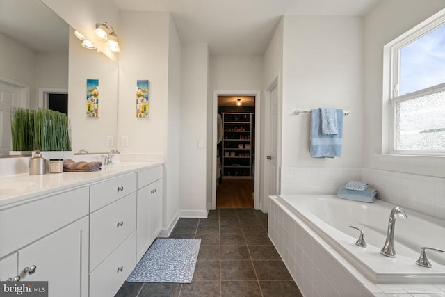 10430 Aspen Highlands Dr, Spotsylvania, VA 22553 - bathroom with a spacious closet, double vanity, a bath, and baseboards