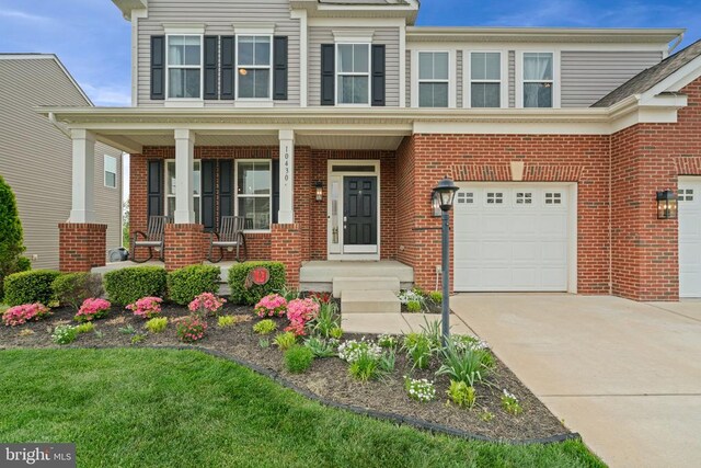 10430 Aspen Highlands Dr, Spotsylvania, VA 22553 - view of front of house featuring an attached garage, brick siding, driveway, and a porch