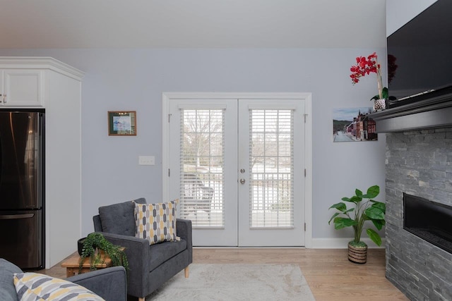 215 Heather Ln, Staunton, VA 24401 - living area with baseboards, a stone fireplace, light wood finished floors, and french doors