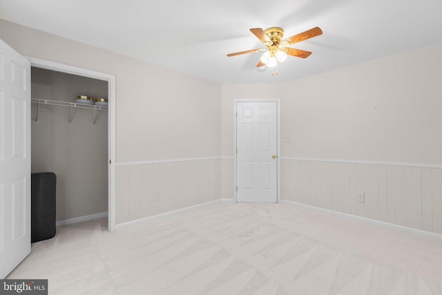 10911 Jarvis Ct, Fredericksburg, VA 22407 - unfurnished bedroom with wainscoting, a closet, carpet floors, wood walls, and a ceiling fan