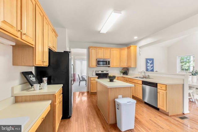 10911 Jarvis Ct, Fredericksburg, VA 22407 - kitchen with appliances with stainless steel finishes, light brown cabinetry, a peninsula, light countertops, and light wood finished floors