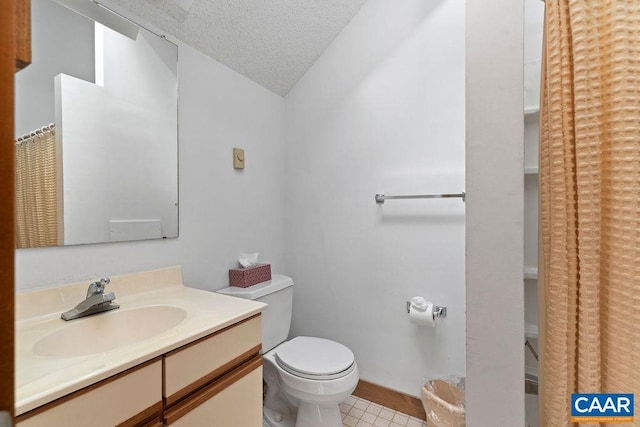 bathroom featuring toilet, vanity, a textured ceiling, tile patterned floors, and baseboards
