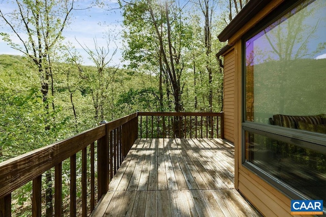 wooden terrace featuring a view of trees