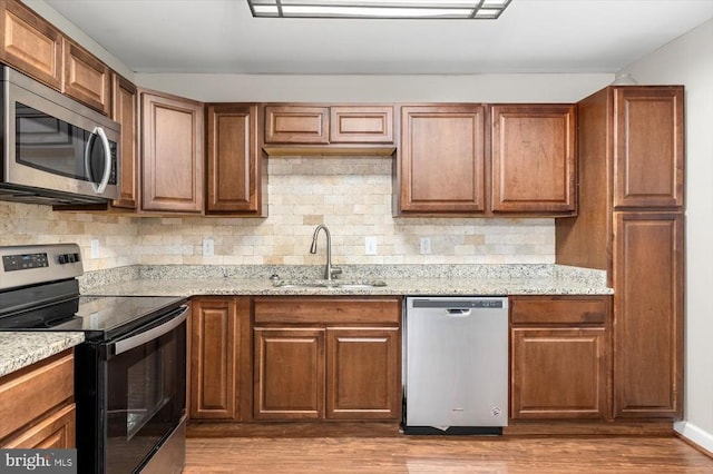 6908 Wild Turkey Dr, Spotsylvania, VA 22553 - kitchen featuring stainless steel appliances, wood finished floors, tasteful backsplash, and light stone countertops