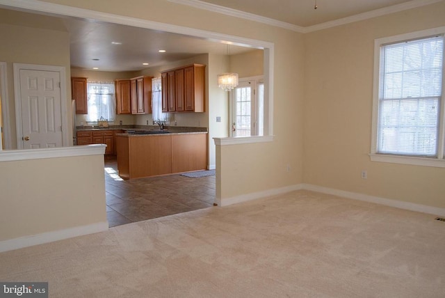 kitchen with healthy amount of natural light, carpet floors, baseboards, ornamental molding, and recessed lighting