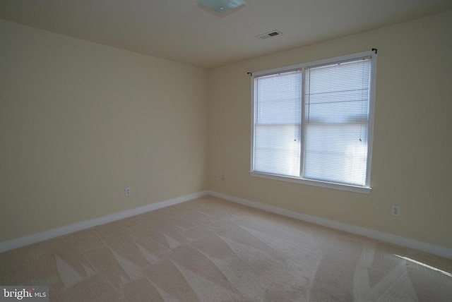 unfurnished room with baseboards and light colored carpet