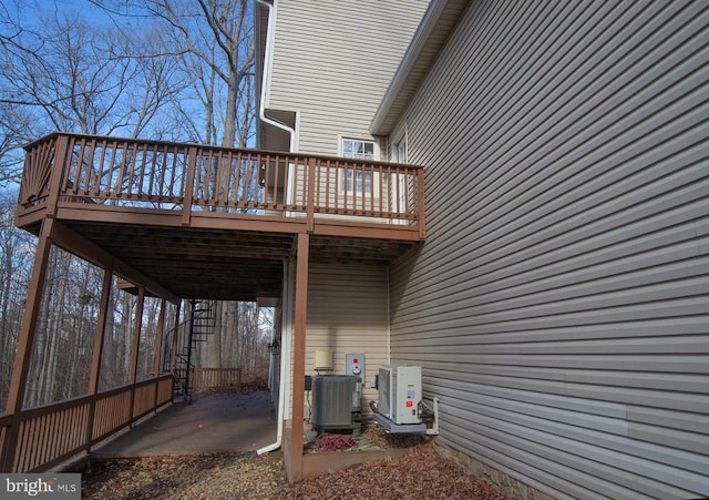 rear view of house featuring a deck, cooling unit, and a cooling unit