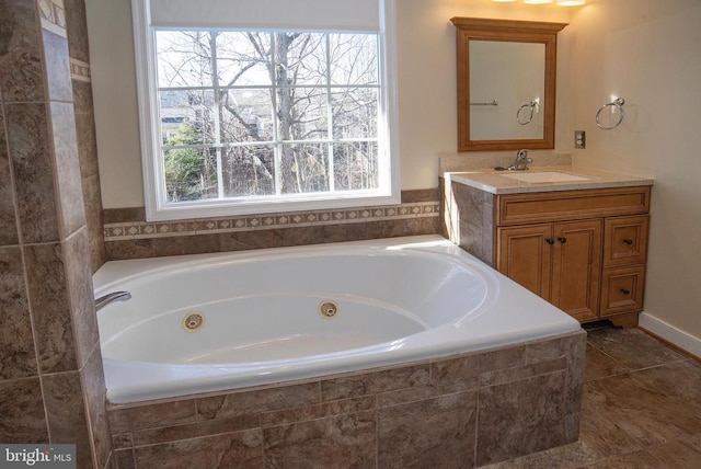 bathroom with a tub with jets and vanity