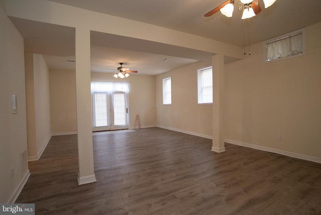 unfurnished living room featuring a ceiling fan, dark wood-style flooring, and baseboards