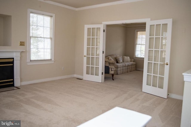 unfurnished room featuring french doors, ornamental molding, carpet floors, a fireplace with flush hearth, and baseboards