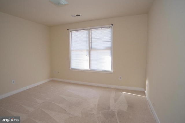 unfurnished room featuring light colored carpet and baseboards