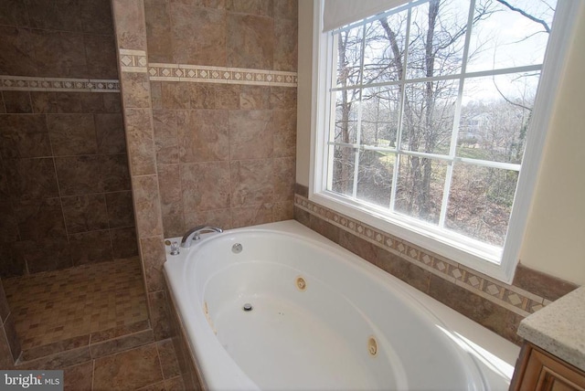 bathroom with a jetted tub, vanity, and walk in shower