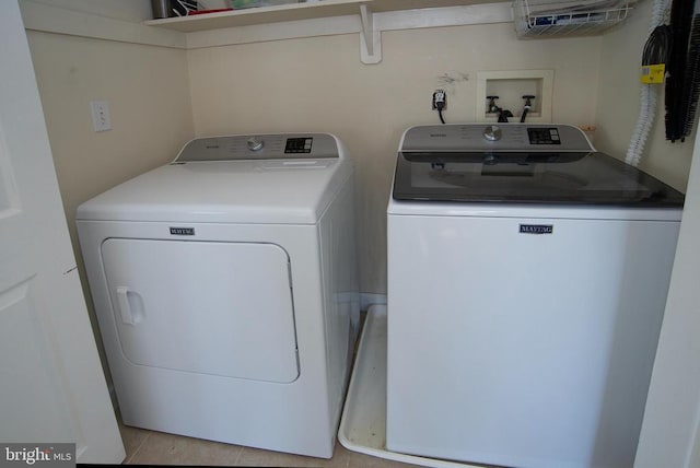 laundry room featuring independent washer and dryer and light tile patterned floors