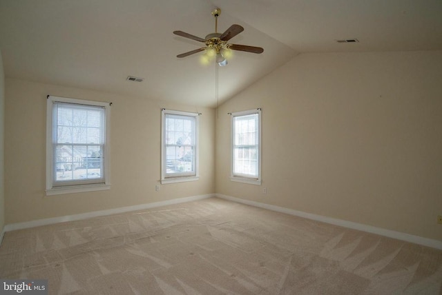 unfurnished room featuring ceiling fan, light carpet, plenty of natural light, and lofted ceiling