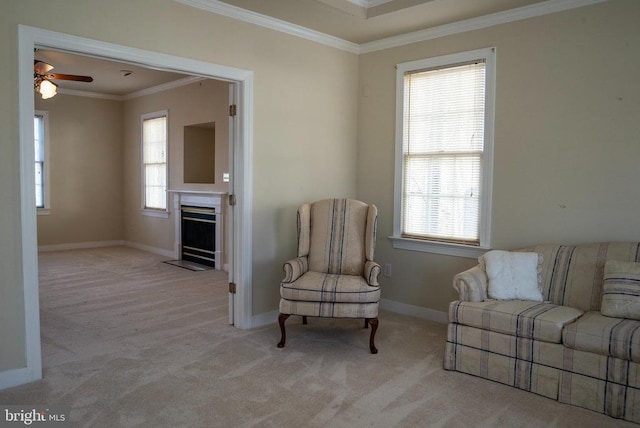 living area featuring carpet floors, crown molding, a ceiling fan, and plenty of natural light