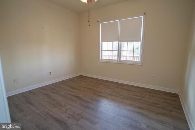 unfurnished room featuring dark wood-type flooring, baseboards, and ceiling fan
