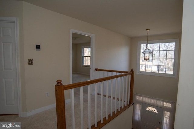 stairway with a chandelier, carpet, and baseboards