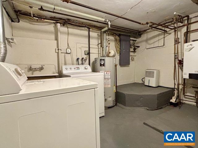 laundry room with gas water heater, washer and dryer, and electric panel