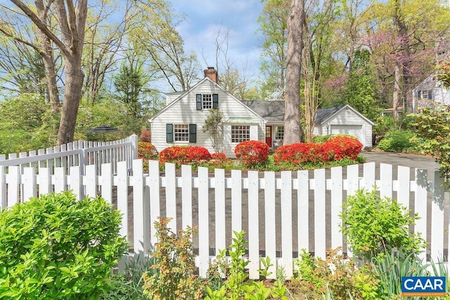 view of home's exterior featuring a chimney, a detached garage, and driveway