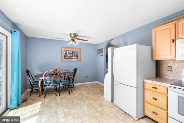 11428 Orange Plank Rd, Locust Grove, VA 22508 - kitchen featuring white appliances, light brown cabinetry, tile counters, a ceiling fan, and arched walkways