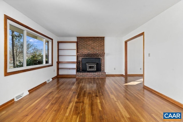 492 Avon Rd, Afton, VA 22920 - unfurnished living room featuring baseboards, a brick fireplace, visible vents, and wood finished floors