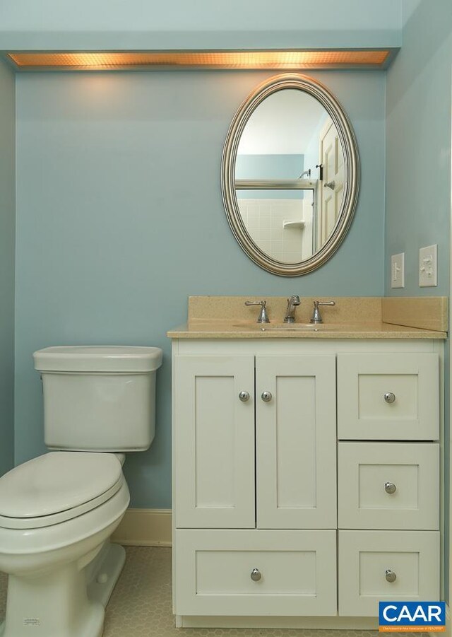 bathroom featuring baseboards, vanity, and toilet