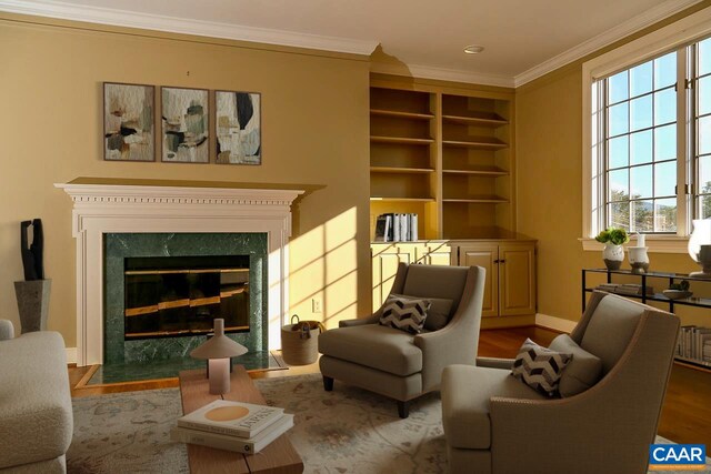 sitting room with wood finished floors, ornamental molding, baseboards, built in features, and a fireplace