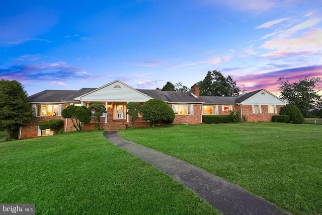  - ranch-style home with brick siding, a front lawn, and a chimney