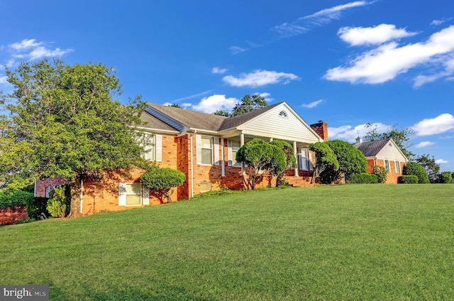  - view of front of property featuring brick siding, a front yard, and covered porch