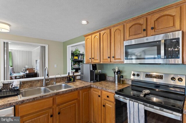 2266 Honeyville Rd, Stanley, VA 22851 - kitchen featuring appliances with stainless steel finishes, a sink, a textured ceiling, brown cabinetry, and recessed lighting
