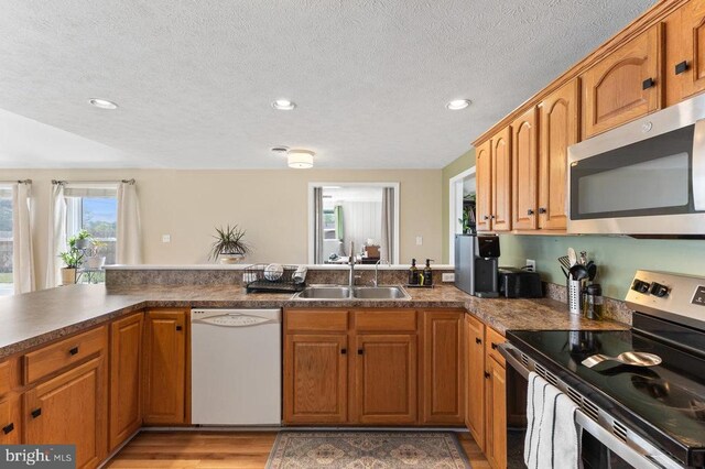 2266 Honeyville Rd, Stanley, VA 22851 - kitchen with appliances with stainless steel finishes, a sink, brown cabinets, a peninsula, and recessed lighting