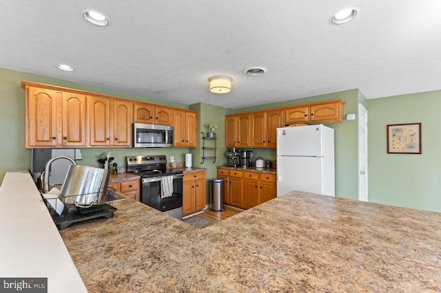 2266 Honeyville Rd, Stanley, VA 22851 - kitchen featuring appliances with stainless steel finishes, wood finished floors, recessed lighting, and brown cabinetry