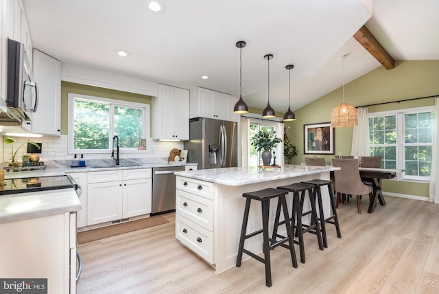  - kitchen featuring appliances with stainless steel finishes, light wood-style floors, healthy amount of natural light, decorative backsplash, and recessed lighting