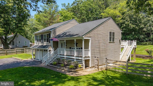  - split level home with stairs, an attached garage, driveway, a shingled roof, and covered porch