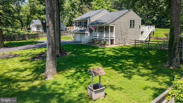  - view of front of home with stairway, a garage, driveway, and a fenced backyard