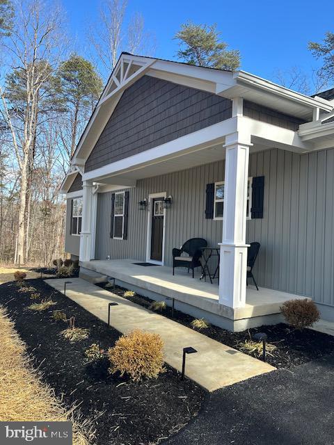 back of house with a porch and board and batten siding
