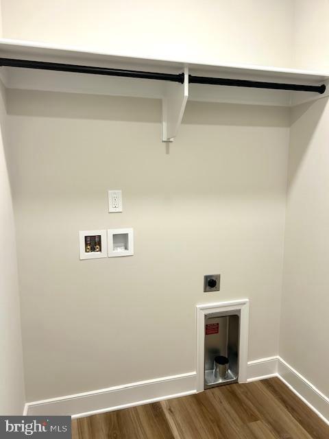washroom featuring washer hookup, electric dryer hookup, wood finished floors, and baseboards