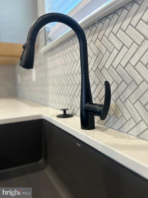 kitchen view of a sink and light countertops